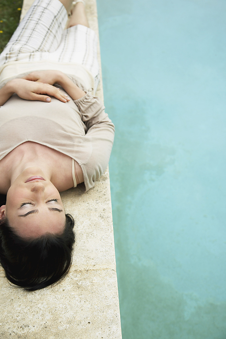 Woman Lying By Pool, by Masterfile / Design Pics