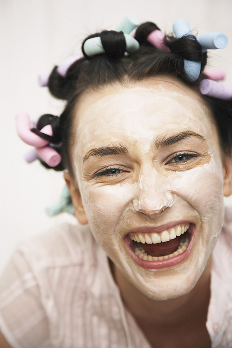 Woman Wearing Face Cream And Curlers, by Masterfile / Design Pics