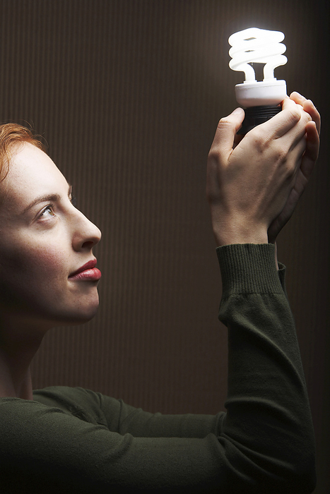 Woman Holding Energy Efficient Light Bulb, by Masterfile / Design Pics