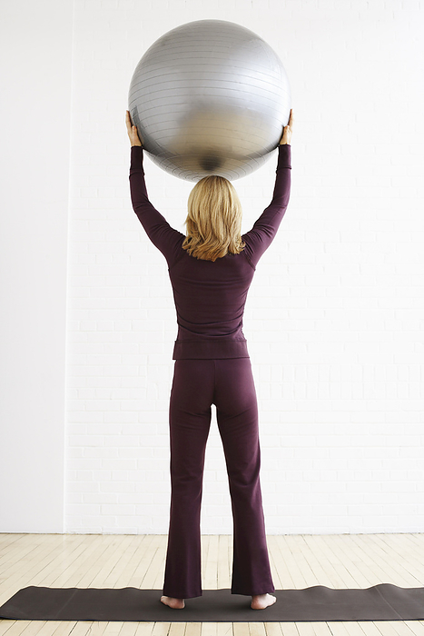 Woman Holding Exercise Ball, by Masterfile / Design Pics