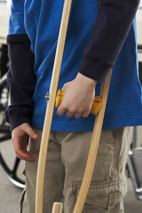 Close-up of Boy's Hand Holding Crutch, by Masterfile / Design Pics