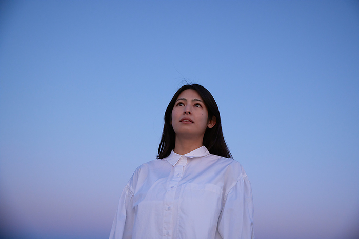 Dawn sky and a Japanese woman looking into the distance