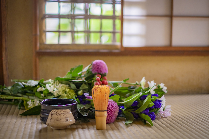 Japanese style flowers and matcha bowl on tatami mats