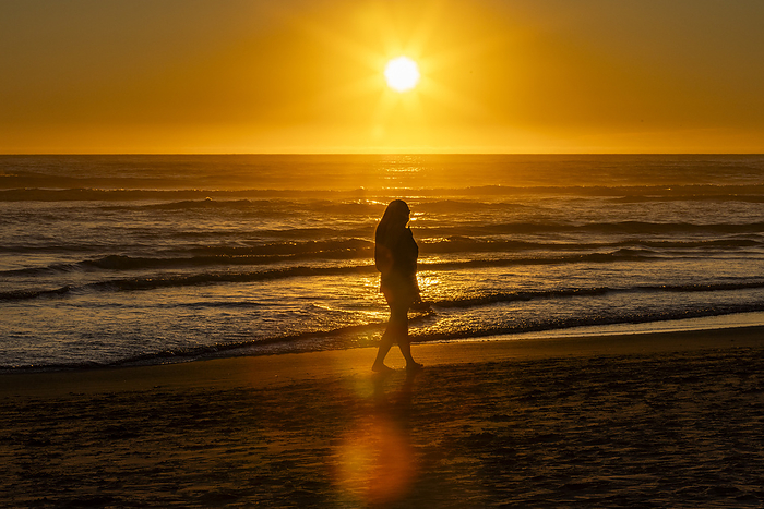 Silhouette of woman walking along Cannon Beach, by Steve Smith