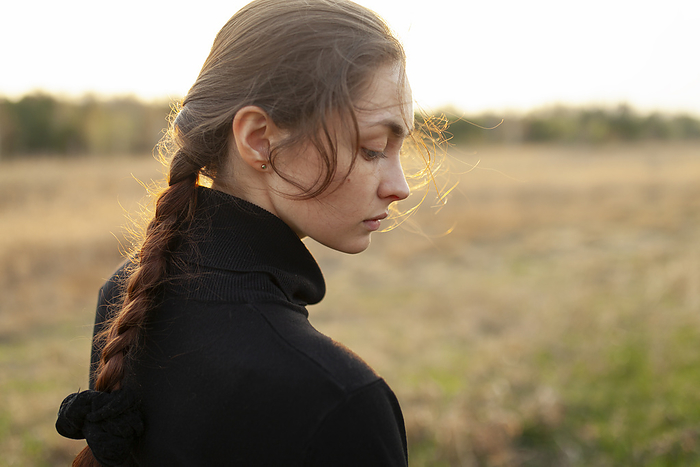 Side view of serious woman standing in field at sunset, by Vyacheslav Chistyakov