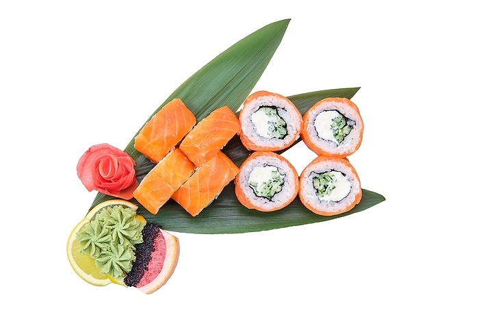 Overhead view of sushi roll with raw salmon fillet on top served on bamboo leaves, by Aleksei Isachenko