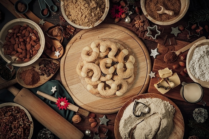 Plates with coffee croissants, baking ingredients, Christmas decorations, flour, sugar, almonds, nuts, cinnamon, cookie cutters, by Lucas Seebacher