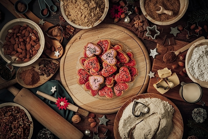 Plate with glazed heart-shaped biscuits, baking ingredients, Christmas decorations, flour, sugar, almonds, nuts, cinnamon, cookie cutters, by Lucas Seebacher