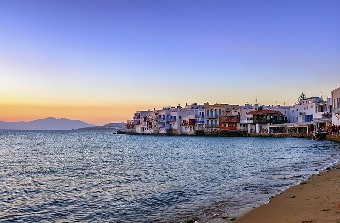 Beautiful sunset view of seafront Little Venice in Chora, Mykonos, Cyclades, Greece. Romantic neighborhood with bars, cafes, restaurants in whitewashed old fisherman houses hanging on cliffs above sea waves, by Natallia Pershaj