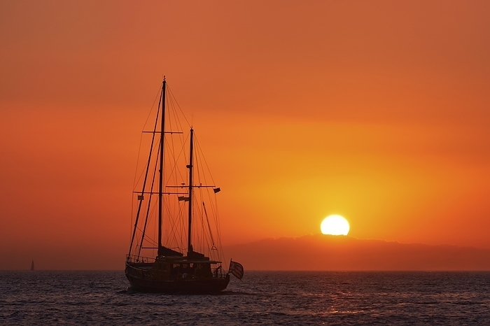 Silhouette of sailing boat with sails down against sun at sunset, sun glare on sea waters. Romantic seascape. Sailboat go to sea. Holiday lifestyle landscape with skyline sailboat. Yachting tourism. Romantic trip on yacht during sea sunset, by Natallia Pershaj