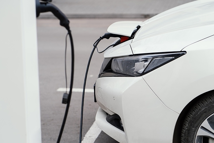 Side view automobile being charged electric vehicle charging station. Beautiful photo, by Oleksandr Latkun