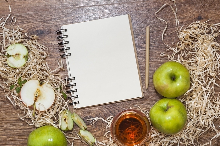 Blank spiral notepad pencil green apple with apple cider vinegar wooden desk, by Oleksandr Latkun