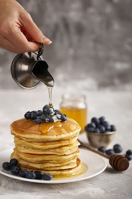 Front view person pouring maple syrop pancakes, by Oleksandr Latkun
