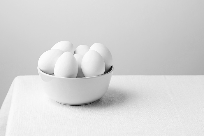Front view white chicken eggs bowl with copy space, by Oleksandr Latkun