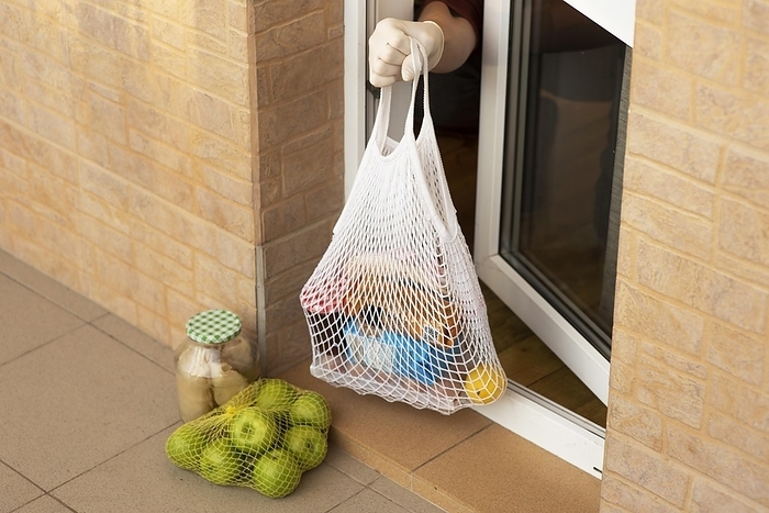 Quarantined person taking groceries from his front door, by Oleksandr Latkun