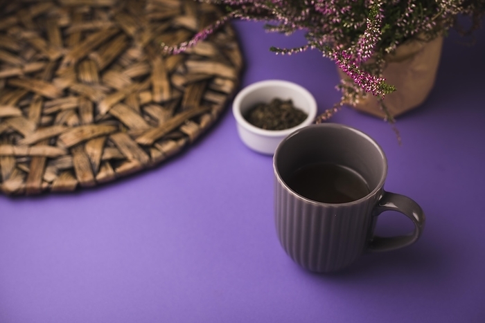 Black tea with herbs coaster purple background, by Oleksandr Latkun