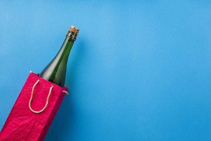 Champagne bottle bright red paper bag blue surface, by Oleksandr Latkun
