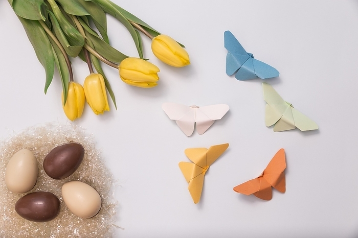 Spring composition with chocolate eggs tulips paper butterflies, by Oleksandr Latkun
