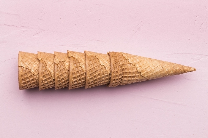 Stacked waffle cones pink background, by Oleksandr Latkun