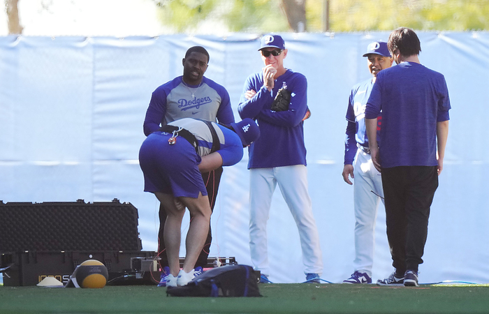 2024 MLB Dodgers camp   Otani falls down and holds his side to surprise Dodgers Shohei Ohtani  foreground , wearing a measuring device and making a dash, suddenly breaks the wire and falls over. He holds his side to surprise the crowd on February 13, 2024 date 20240213 place Glendale, Arizona, U.S.A.