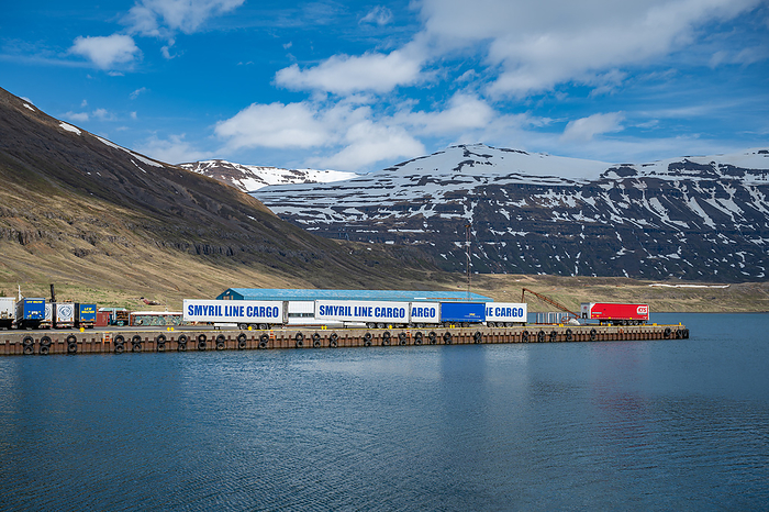 Cargo shipping container at the port harbor of Seydisfjordur, Iceland, view from the distance with mountain range in the background Cargo shipping container at the port harbor of Seydisfjordur, Iceland, view from the distance with mountain range in the background, by Zoonar Markus Beck