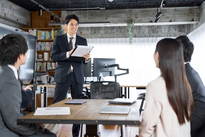 Japanese businessman leading a team in a meeting (Male/Female / People)