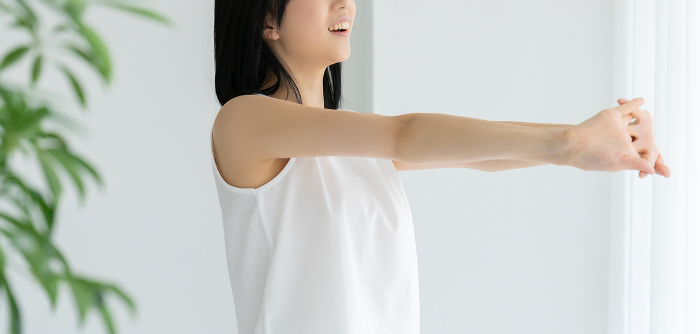 Young woman in white stretching