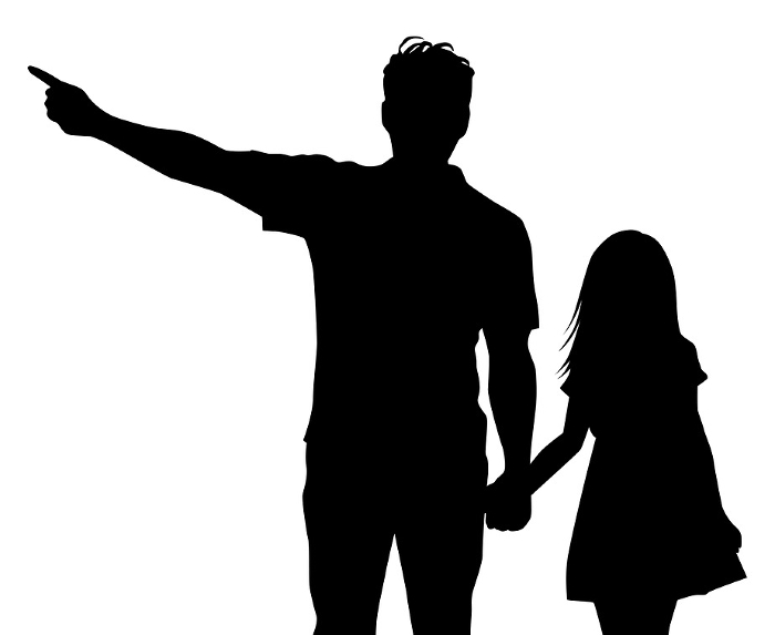 Silhouette of a man holding hands with a girl and pointing