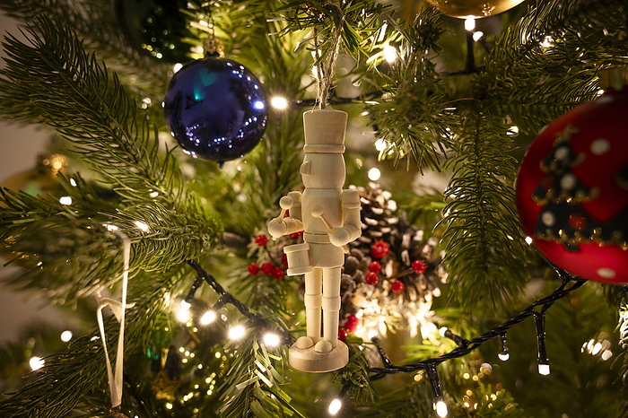 Wooden toy soldier hanging on Christmas tree at home