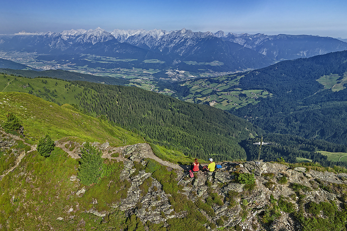 Aerial view of two hikers admiring the view from Gamsstein mountain, Tyrol, Austria
