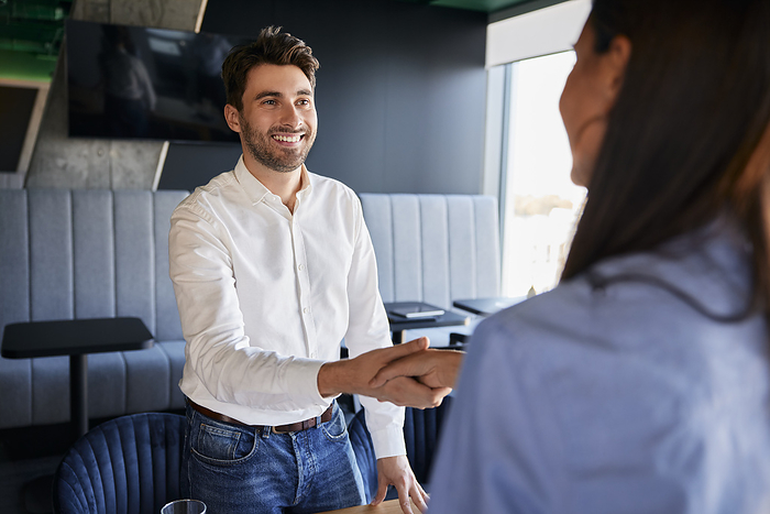 Smiling businessman shaking hands with colleague at office