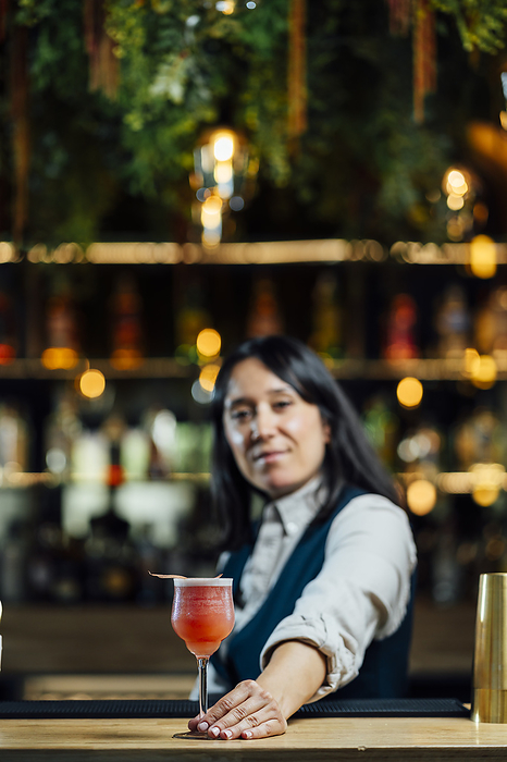 Bartender serving cocktail on bar counter