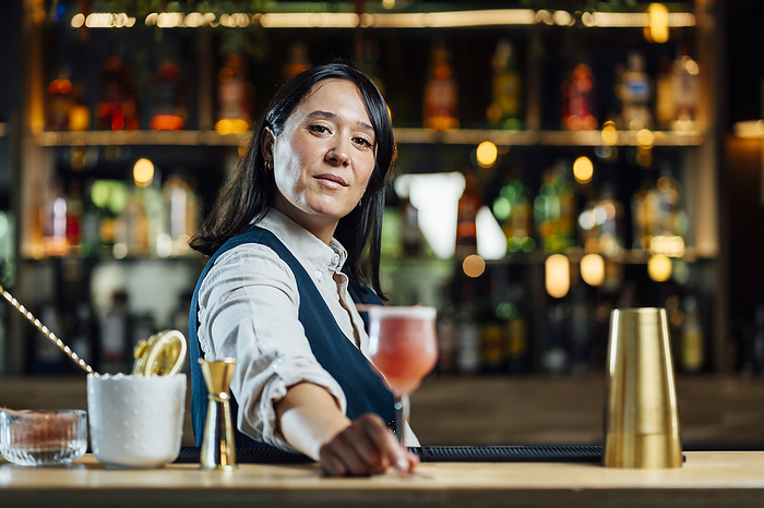 Bartender serving cocktail at bar counter