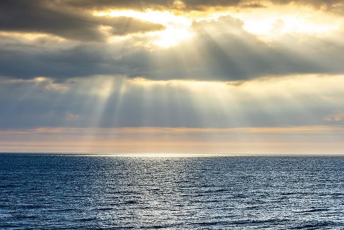 Sylt Germany, Schleswig Holstein, Sun piercing through clouds over North Sea