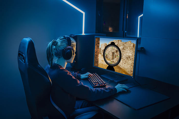 Professional gamer wearing headphones and playing game on computer