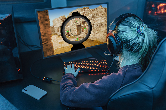 Gamer wearing headset and playing esports on desktop PC