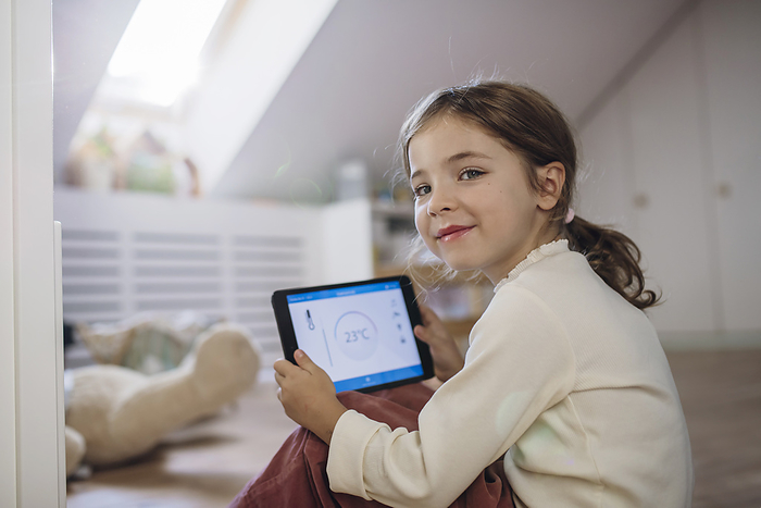 Smiling girl holding tablet PC in attic