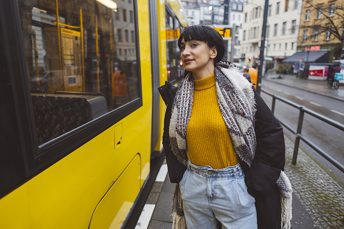 Smiling woman standing near cable car at tram station
