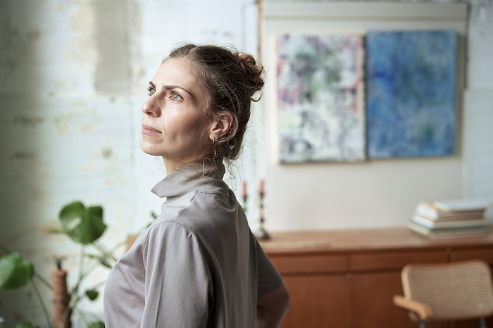 Thoughtful woman standing in art workshop