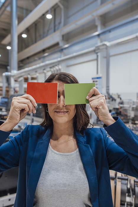 Businesswoman covering eyes with wooden pieces in industry