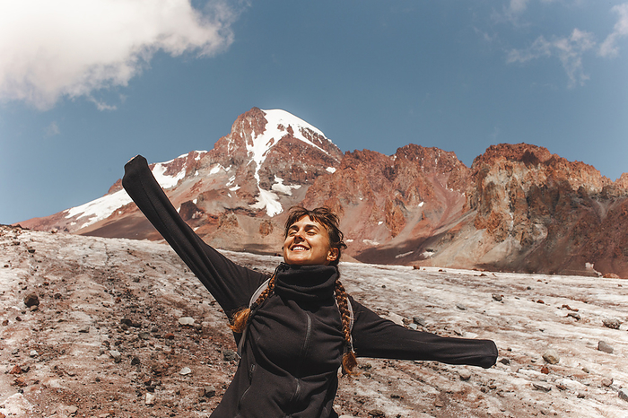 Carefree woman in front of mount Kazbek on sunny day