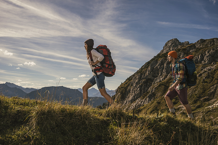 Couple walking on mountain trail in Tannheimer Tal, Tyrol, Austria
