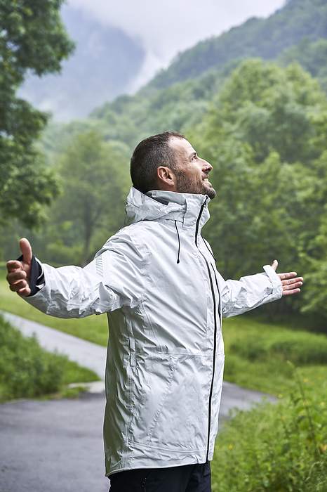 Happy man wearing white jacket in front of Pyrenees mountain