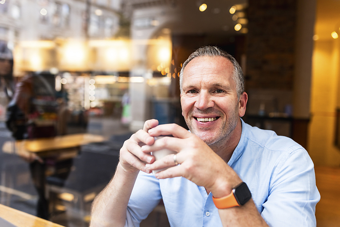 Happy businessman having coffee at cafe
