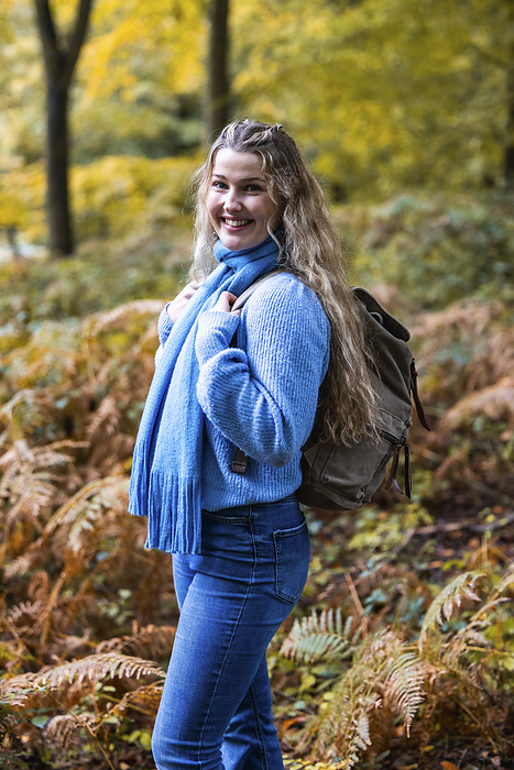 Happy beautiful woman standing with backpack in Cannock chase forest