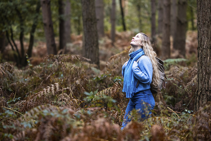 Smiling young woman with backpack in Cannock chase forest
