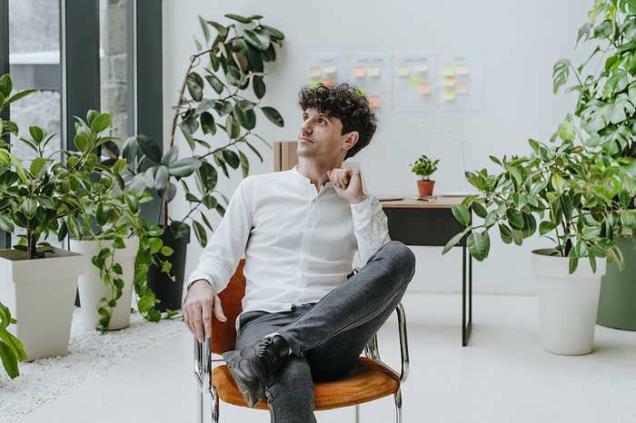 Thoughtful businessman sitting on chair in office