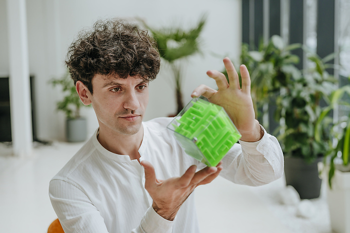 Businessman examining cube maze in office