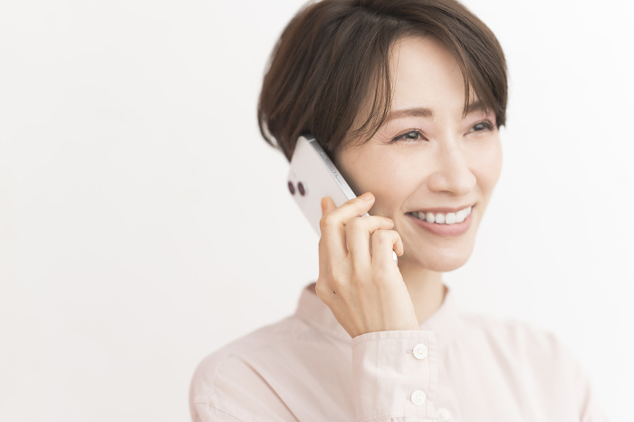 A Japanese woman happily talking on her cell phone.