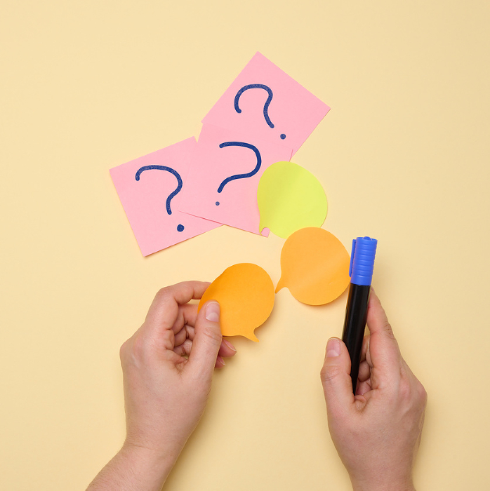 Paper stickers with question marks on a yellow background, searching for an answer Paper stickers with question marks on a yellow background, searching for an answer